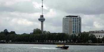Euromast Rotterdam met watertaxi op de voorgrond en op de achtergrond donkere lucht